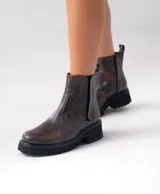 Botas Chelsea de cuero vacuno negro con elásticos laterales, cierre interno y suela de goma artesanal.