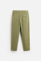 Pantalón verde oliva de corte relaxed fit, confeccionado en tejido de algodón con textura. Tiene cintura elástica ajustable con cordón, bolsillos frontales y un bolsillo trasero de parche.
