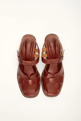 Sandalias plateadas de cuero con tiras entrecruzadas y hebilla lateral. Taco de madera de 6 cm.