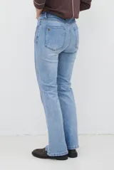 Jean de corte semi oxford con tiro medio, confeccionado en denim de lavado claro. Presenta costuras verticales decorativas en el frente y un detalle de costura en la botamanga que amplía la silueta.