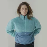 Buzo celeste con parte superior de sherpa y parte inferior de nylon, con cierre frontal a la mitad y bolsillo tipo canguro con logo de la marca.