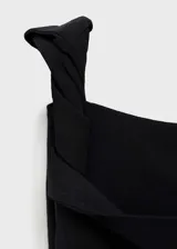 Vestido largo negro asimétrico, con un solo tirante ancho, escote off-shoulder, detalles fruncidos y cierre lateral con cremallera.