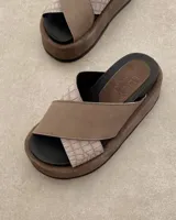 Sandalias Lucy de cuero color beige con tiras cruzadas y suela plana.