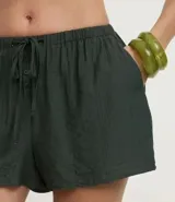 Short de playa suelto color beige, confeccionado en viscosa certificada, con cintura elástica ajustable mediante lazo y bolsillos laterales.