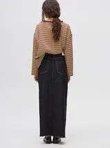 Falda midi de denim color marrón con hilado a la vista en el ruedo y abotonadura frontal.