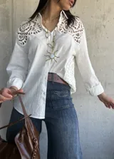 Camisa blanca de lino con detalles de encaje en los hombros y mangas 3/4.