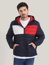 Campera acolchada Tommy Hilfiger, con capucha y cierre frontal. Diseño color block en azul marino, blanco y rojo.