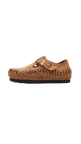 Zapato marrón de cuero con hebilla y detalle de trenzado en el borde.