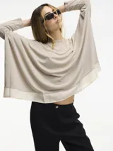 Sweater negro de fit amplio con mangas ajustadas y detalle de superposición en el bajo.