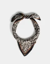 Pañuelo cuadrado de tela fina con estampado animal print en tonos beige, marrón y negro. Tiene borde con puntilla de crochet.