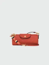 Bandolera Longchamp modelo Le Pliage Xtra, tamaño S, color terracota, con correa de cuero ajustable y cierre con botón a presión.