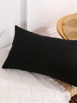 Funda de almohadón rectangular color negro, de 28 x 48 cm.
