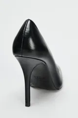 Zapato de tacón fino negro, con escote redondo y acabado en punta.