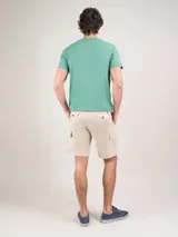 Bermuda color beige, corte regular fit, con cierre elástico y cordones en la cintura. Cuenta con bolsillos cargo laterales y detalles en los bolsillos.