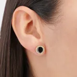 Aros circulares con centro negro y borde dorado con pequeños brillantes.