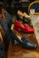 Zapato clásico de cuero azul marino, con aplique decorativo en el empeine y taco cuadrado.