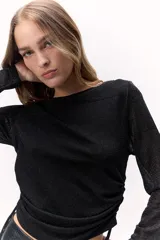 Remera negra de manga larga, con cuerpo brillante y ajuste entallado.