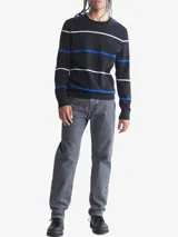 Sweater negro de algodón con rayas horizontales blancas y azules. Tiene cuello redondo y logo de Calvin Klein bordado en el pecho.