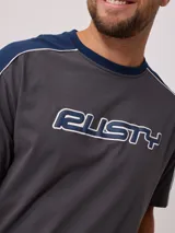 Remera de hombre azul marino con mangas y cuello amarillo, y logo de la marca Rusty estampado en el pecho.