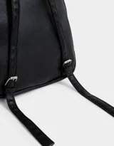 Mochila negra de cuerina con correas regulables, manija superior, cierre superior con doble deslizador, bolsillo frontal con cierre y deslizador, etiqueta metálica y bolsillos laterales.