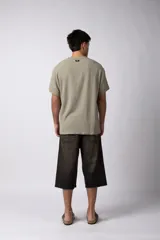 Remera color crudo de lino con textura entramada, calce cómodo y mangas cortas.