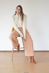 Pantalón de algodón color durazno, de silueta amplia y tiro alto, con diseño de triángulo en los laterales y cierre frontal con botones visibles.