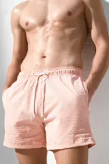 Short de baño color rosa con textura de sirsaca, elástico y cordón ajustable en la cintura, bolsillos laterales, bolsillo trasero ribeteado, aberturas laterales cortas y suspensor interior de malla.