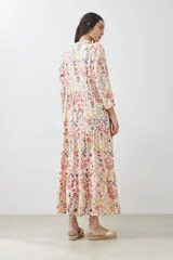 Maxi vestido estampado multicolor con cuello camisero, manga larga y falda larga con volados.