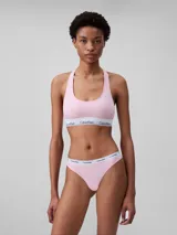 Conjunto Calvin Klein de ropa interior deportiva, compuesto por un corpiño con espalda racerback y una colaless, ambos en color rosado con elástico blanco con el logo de la marca.
