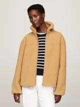 Campera color beige de tejido polar de peluche, con cuello alto, cierre de cremallera, bolsillos laterales y puños elásticos.