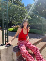 Pantalón midi con estampado de cuadrillé rojo y blanco, con aberturas laterales que se ajustan con lazos.