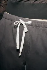Pantalón de tiro medio con cintura elástica ajustable con cordones, bolsillos laterales ocultos en costura y pierna ancha. Confeccionado en hilatura con algodón y lyocell.