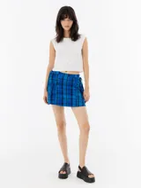Minifalda azul con estampado a cuadros negros, corte recto y lazos laterales ajustables.