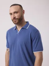 Remera azul con cuello polo y mangas cortas con ribete blanco.