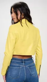 Chaqueta corta de cuero vegano color amarillo con cierre cruzado y detalles en negro.