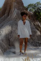 Camisa blanca de broderie con escote en V y mangas largas.