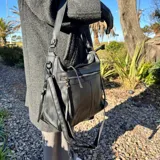 Bolso tipo tote de cuero sintético color marrón, con doble asa de hombro y cierre superior. Incluye monedero de regalo.