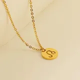 Collar dorado con dije redondo con el signo de Aries grabado.