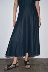 Falda midi de denim azul oscuro, de tiro medio, corte evasé y cierre trasero con cremallera metálica.
