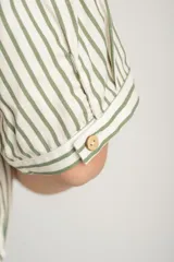 Camisa oversize a rayas verticales color verde y blanco, con cuello clásico, manga corta y cierre frontal con botones.