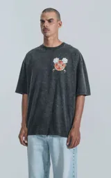Remera negra con efecto acid wash, corte holgado y estampa frontal con diseño alusivo a Disney.