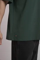 Remera verde oscuro de corte oversize con estampado pequeño en el frente.