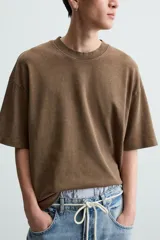 Camiseta azul marino de corte holgado, confeccionada en algodón con cuello redondo y mangas cortas. Presenta un efecto de lavado que le da una apariencia única.