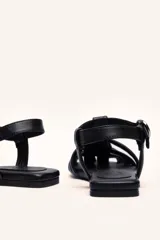 Sandalias franciscanas rojas de cuero con tiras entretejidas y hebilla lateral.