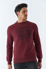 Buzo de felpa color bordó con cuello redondo, mangas largas y corte regular. Presenta un estampado con la frase "Think out of the box" en el frente y logo de la marca bordado.