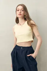 Crop top amarillo pastel sin mangas, de cuello redondo y tejido de punto acanalado.