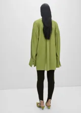 Camisa oversize verde manzana de gasa con lazo en el cuello y aberturas laterales.