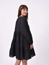 Vestido corto celeste con corte escalonado, mangas abullonadas 3/4 y cuello redondo.