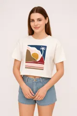 Remera cropped de algodón color crudo, con cuello redondo y estampado abstracto en el frente.