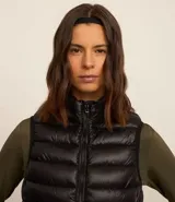 Chaleco puffer deportivo negro confeccionado en poliamida, con cuello alto y cierre frontal con cremallera. Incluye bolsita para guardarlo.